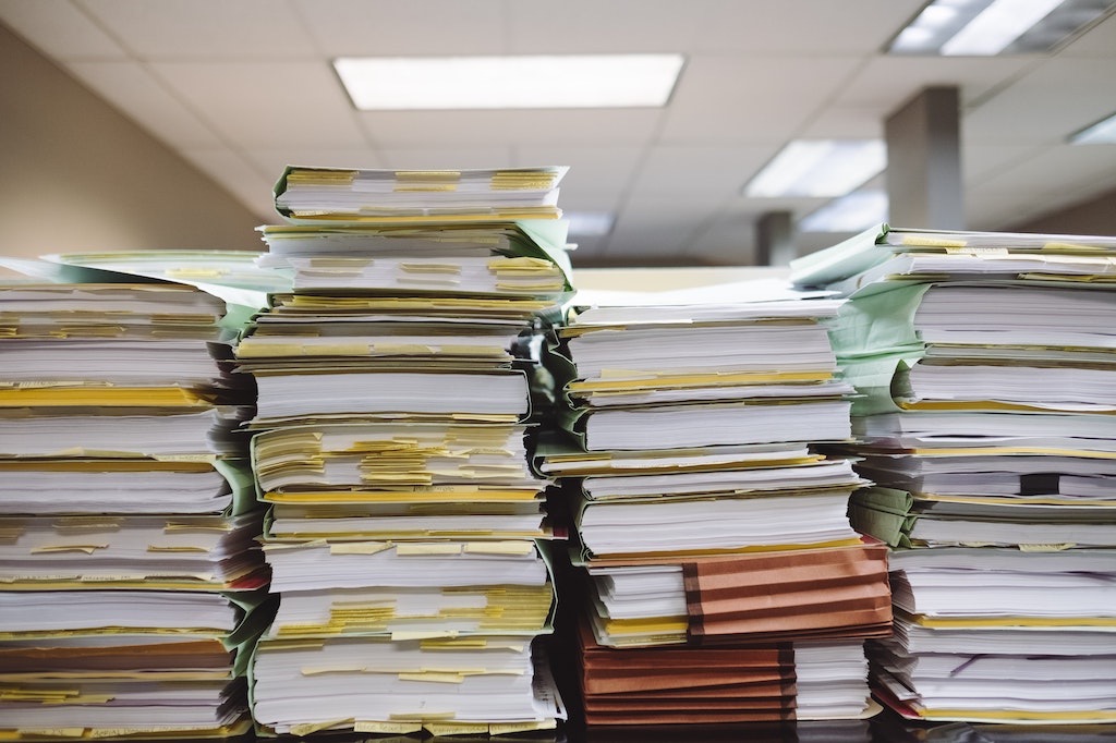 Rows of paperfiles stacked on top of each other in an office 